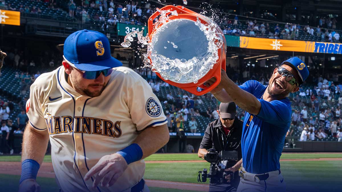 Seattle Mariners centerfielder Julio Rodriguez (44), right, attempts to douse catcher Cal Raleigh (29) with wather after a game against the Athletics at T-Mobile Park.