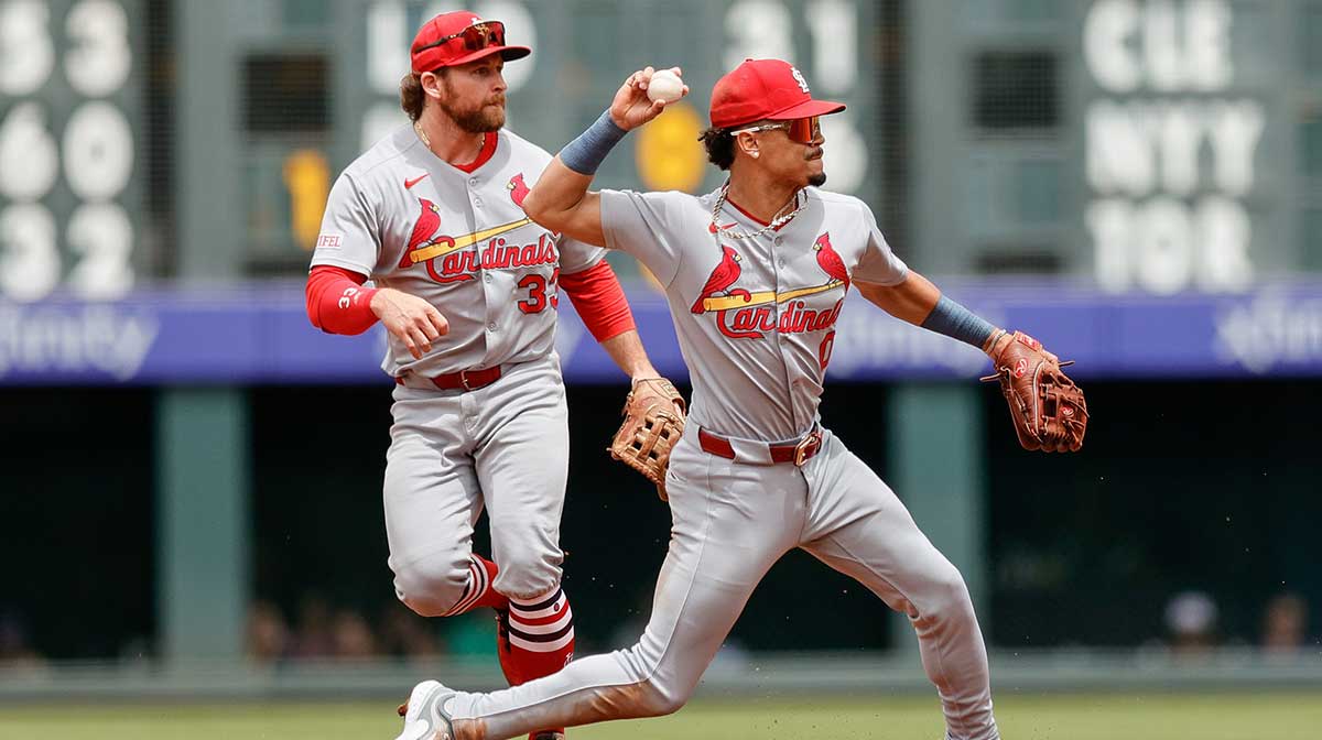 St. Louis Cardinals shortstop Masyn Winn (0) turns the first half of a double play ahead of second baseman Brendan Donovan (33) in the second inning against the Colorado Rockies at Coors Field.