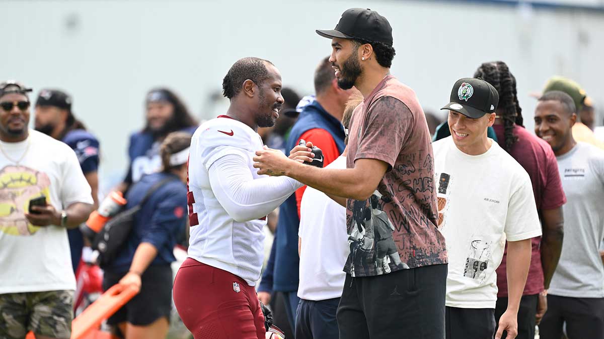 Celtics Jayson Tatum (black hat) forward embraces Washington Commanders linebacker Von Miller (24) at training camp at Gillette Stadium