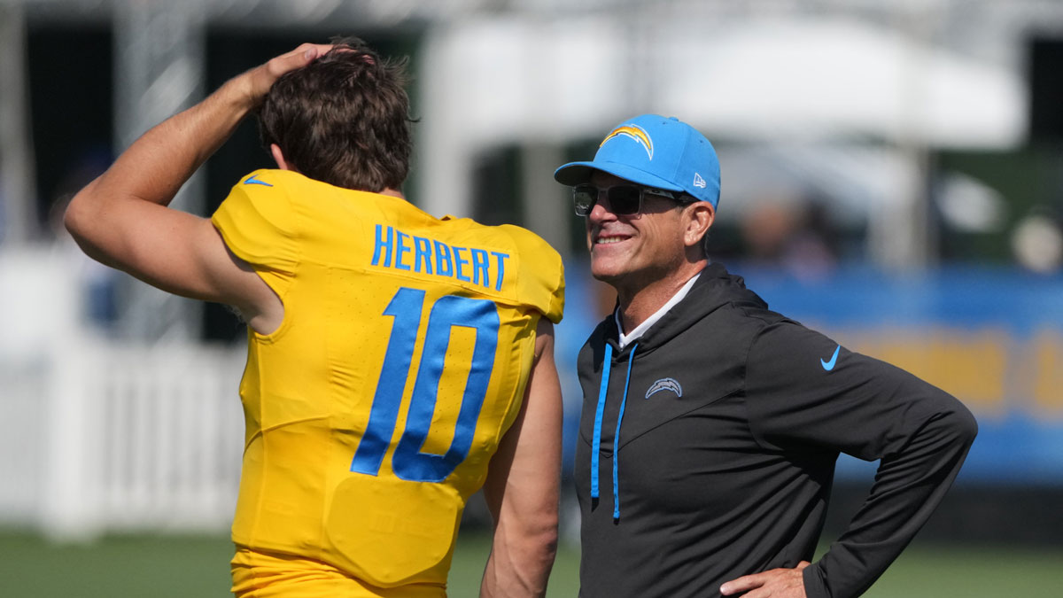 Los Angeles Chargers coach Jim Harbaugh (left) talks with quarterback Justin Herbert (10) during training camp at The Bolt.