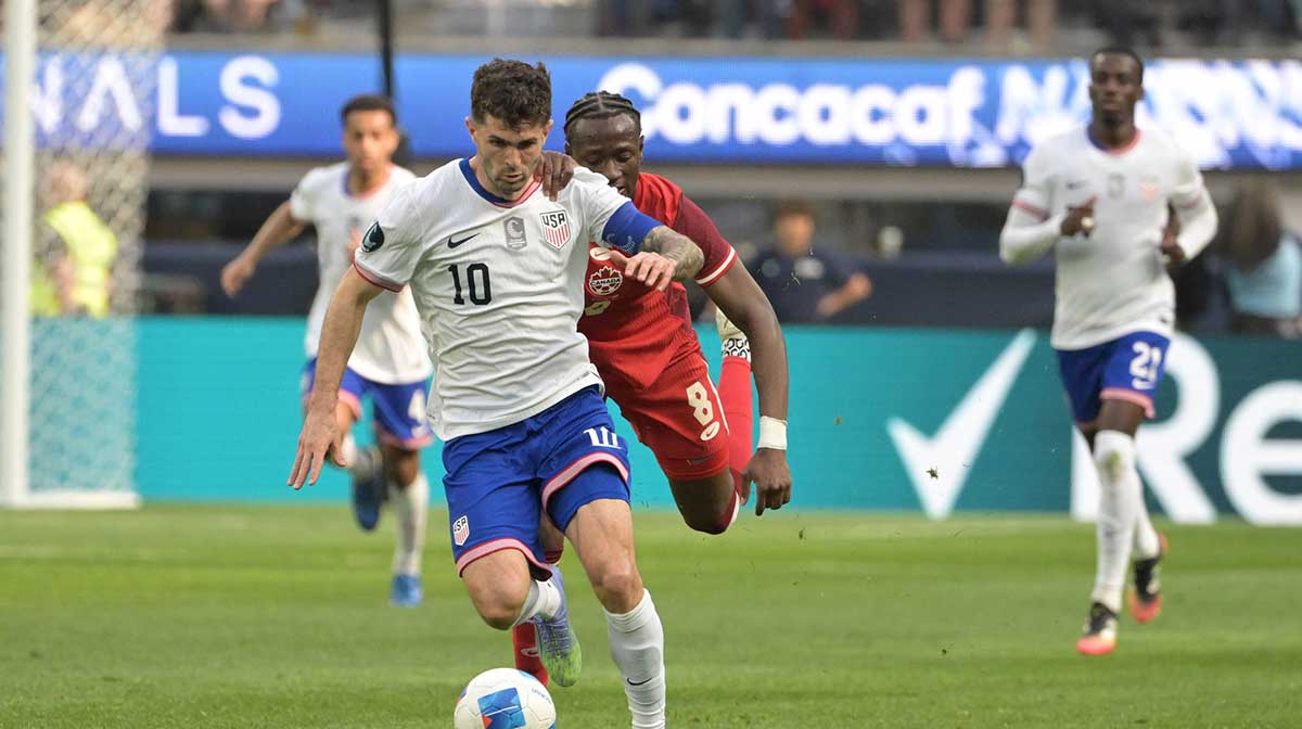 United States of America forward Christian Pulisic (10) kicks the ball past Canada midfielder Ismael Kone (8) in the first half during the Concacaf Nations League third place match at SoFi Stadium.