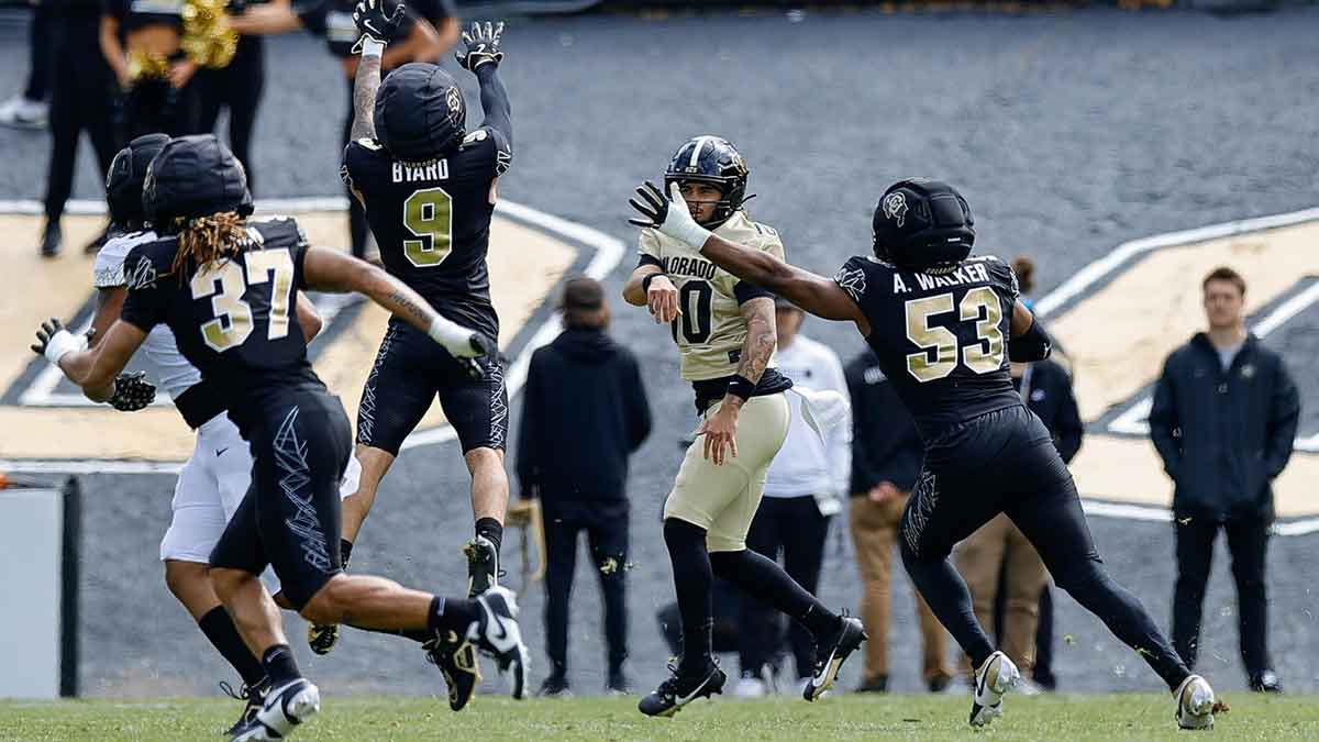 Colorado Buffaloes quarterback Julian Lewis (10) attempts a pass as safety Tawfiq Byard (9) and defensive end Arden Walker (53) and linebacker Martavius French (37) defend during the spring game at Folsom Field.
