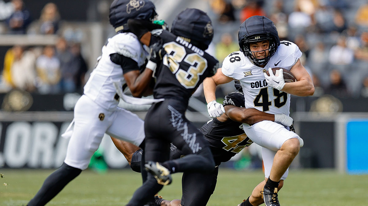 Colorado Buffaloes running back Christian Sarem (48) is tackled by inside linebacker Jeremiah Brown (42) as wide receiver Quentin Gibson (15) defends against cornerback Kole Mathis (33) during the spring game at Folsom Field.
