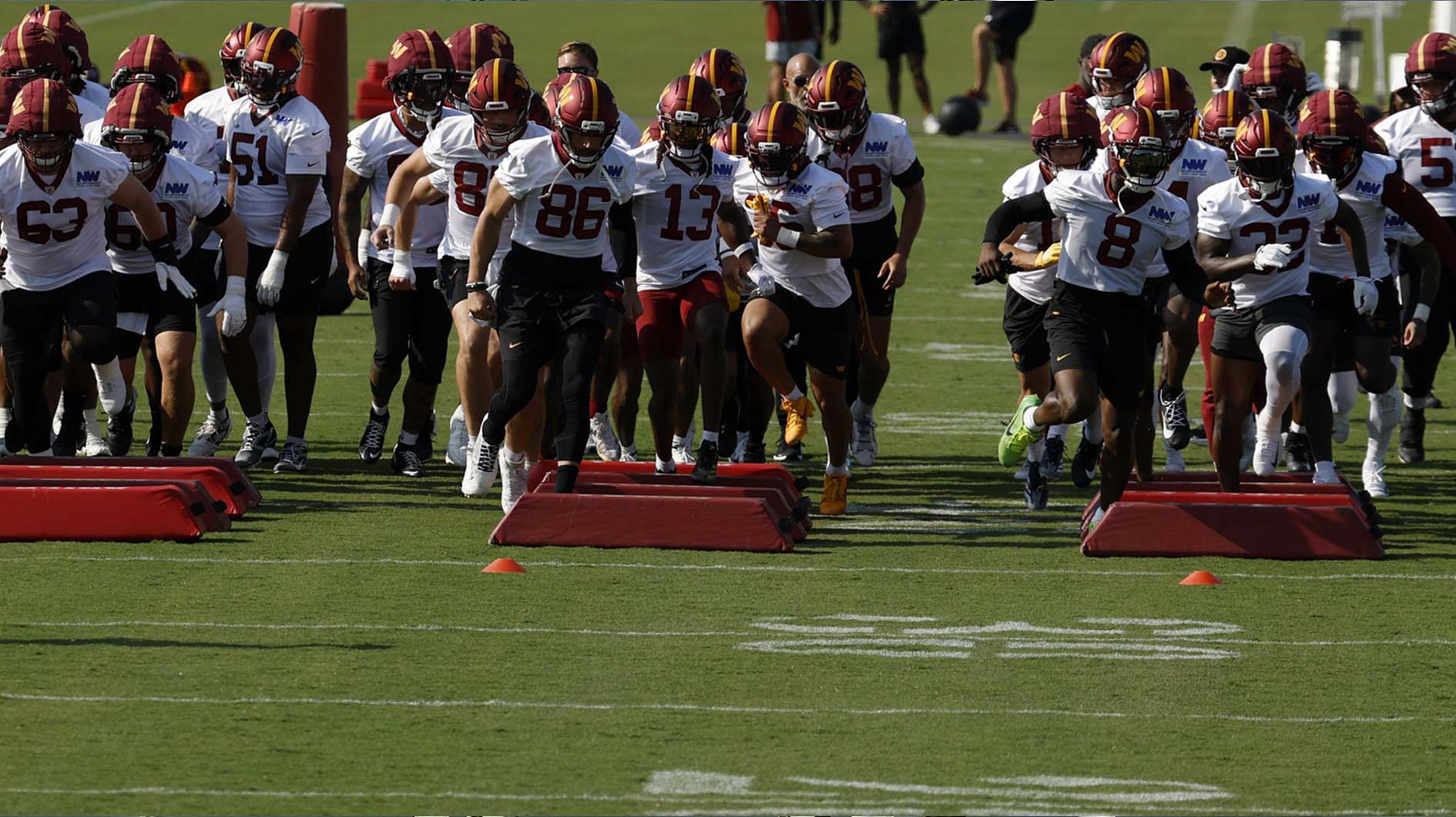 Washington Commanders players participate in warmup drills prior to practice on day two of training camp at OrthoVirginia Training Center at Commanders Park.