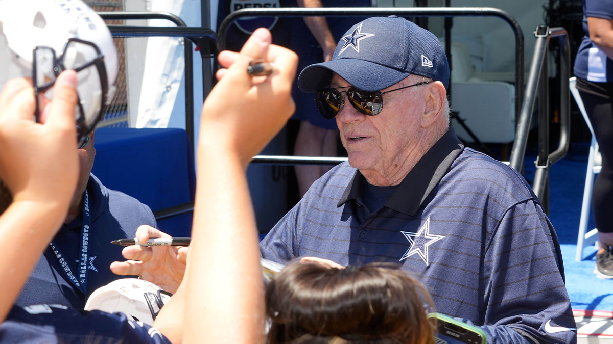 Dallas Cowboys owner Jerry Jones signs autographs at training camp at the River Ridge Fields.