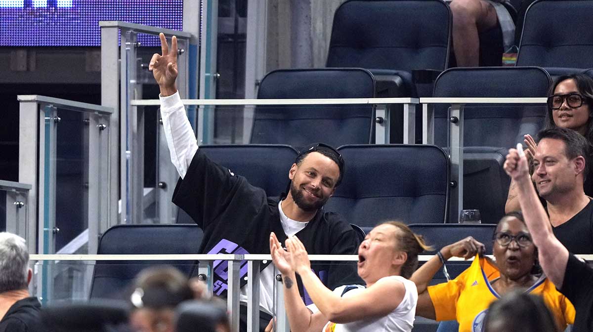 Golden State Warriors guard Stephen Curry (center) waves during the second quarter of the game between the Golden State Valkyries and the Seattle Storm at Chase Center.