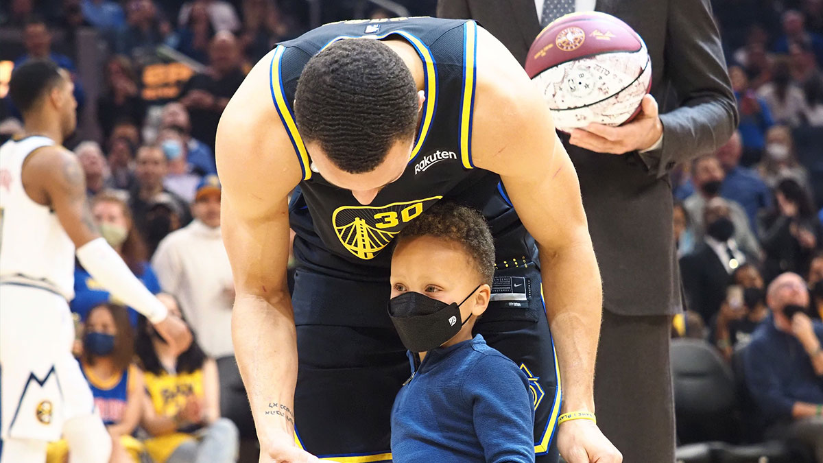 Golden State Warriors guard Stephen Curry (30) with his son, Canon Curry, as he receives his all star jersey before the game against the Denver Nuggets at Chase Center.