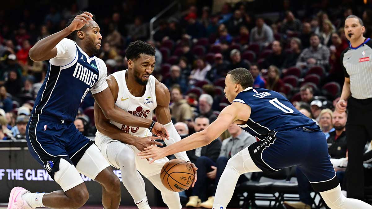 Cleveland Cavaliers guard Donovan Mitchell (45) drives to the basket between Dallas Mavericks forward Olivier-Maxence Prosper (8) and guard Dante Exum (0) during the second half at Rocket Mortgage FieldHouse.