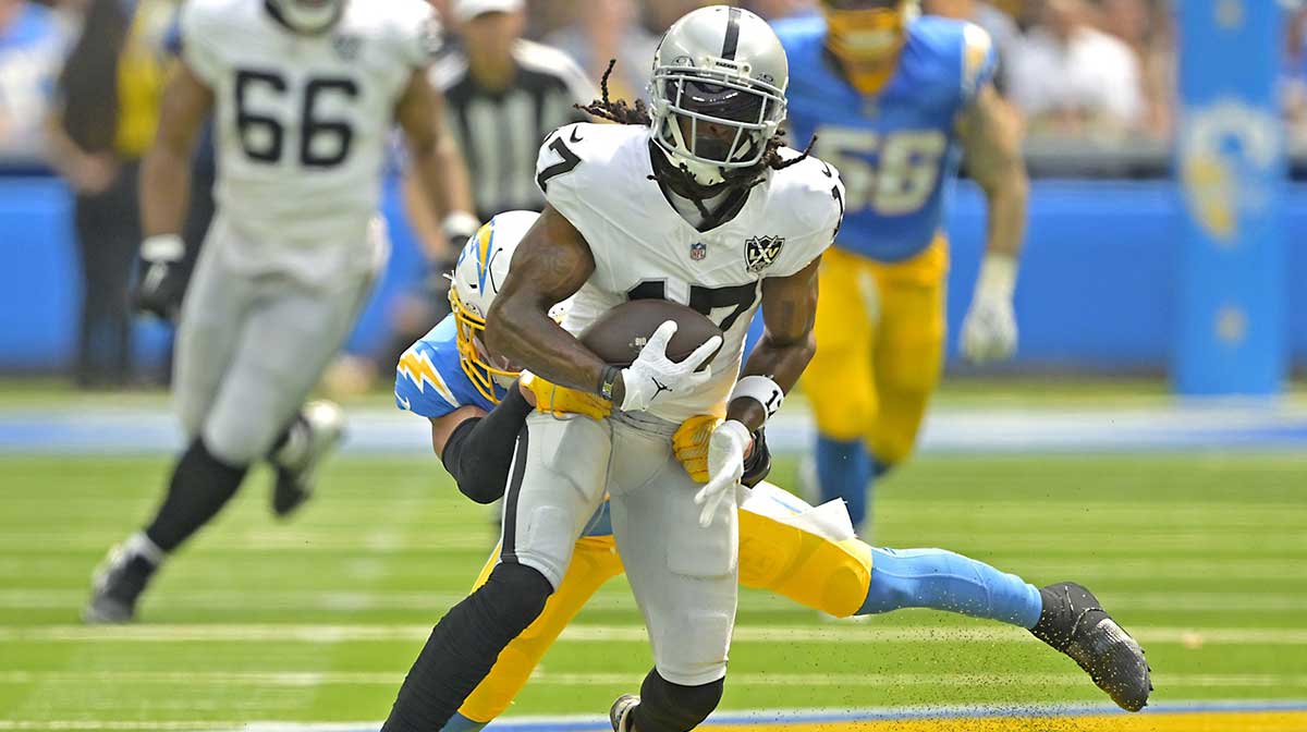 Las Vegas Raiders wide receiver Davante Adams (17) is stopped by Los Angeles Chargers safety Alohi Gilman (32) after a compete pass in the first half at SoFi Stadium.