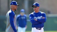 Los Angeles Dodgers second baseman Mookie Betts (50) talks with manager Dave Roberts (30) during spring training at Camelback Ranch.