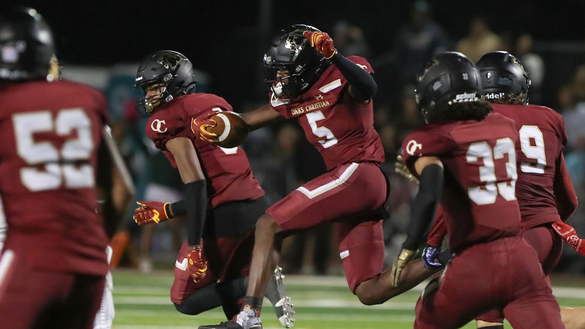 Oaks Christian's Davon Benjamin leaps through an opening after making an interception of a St. Bonaventure pass during the third quarter of the Marmonte League title game on Friday, Oct. 27, 2023, at Oak Christian's Thorson Stadium. Oaks Christian won 13-10.