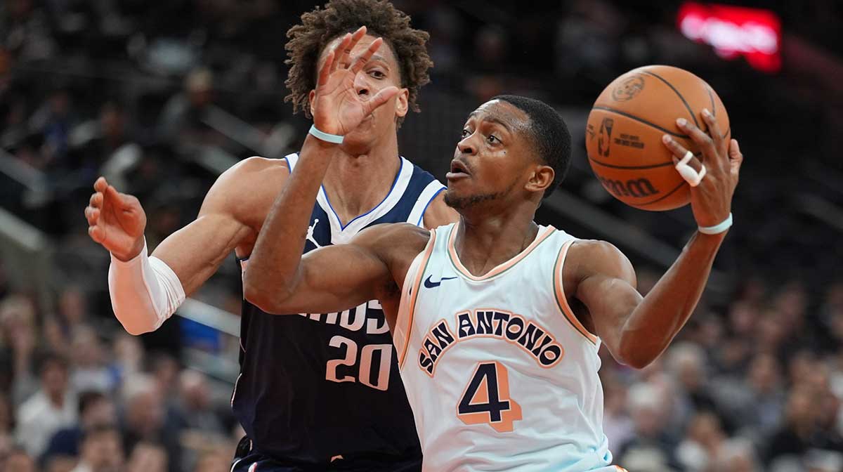Dallas Mavericks forward Kessler Edwards (20) defends against San Antonio Spurs guard De'Aaron Fox (4) in the first half at Frost Bank Center.