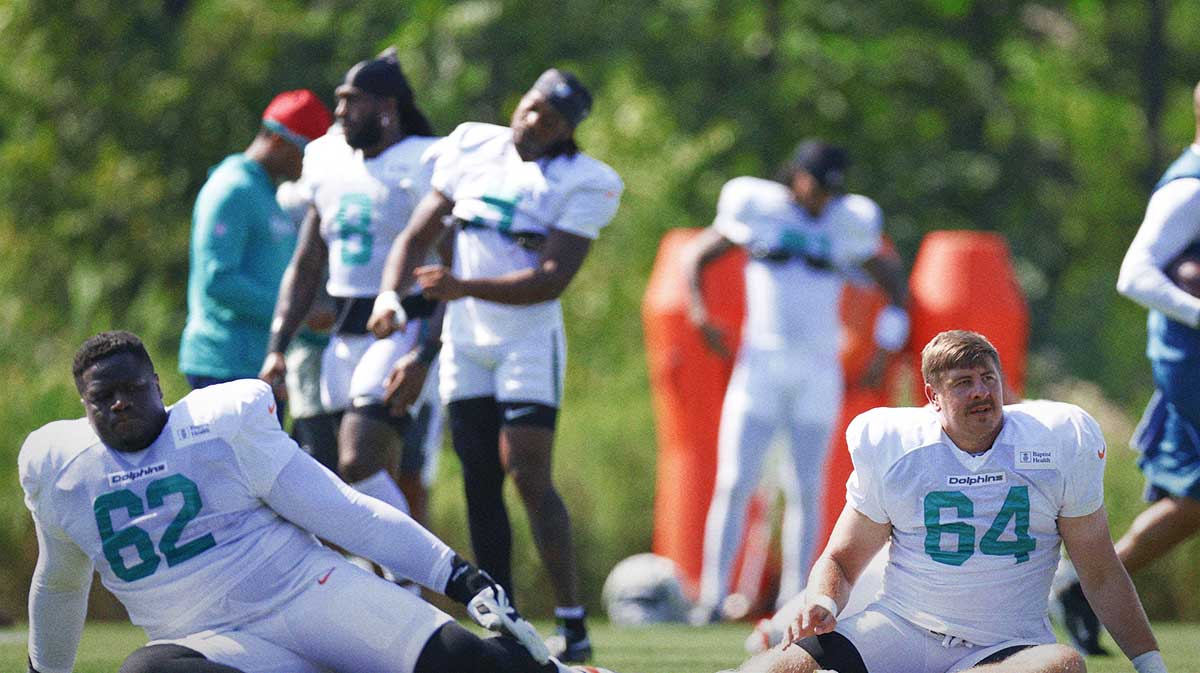 Miami Dolphins guard Germain Ifedi (62) and offensive tackle Daniel Brunskill (64) stretch during joint training camp practice with the Chicago Bears ahead of Sunday's preseason opener.
