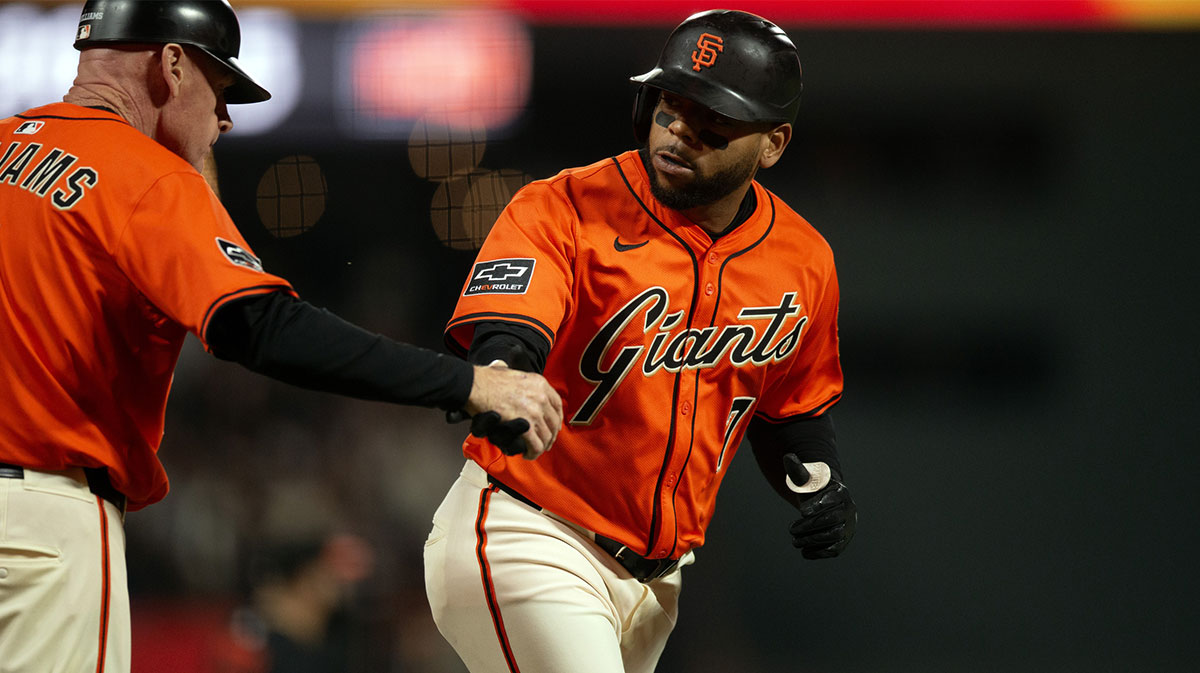 San Francisco Giants first baseman Dom Smith (7) gets a congratulatory handshake from third base coach Matt Williams (9) as he runs out his two-run home run against the Baltimore Orioles during the fourth inning at Oracle Park.