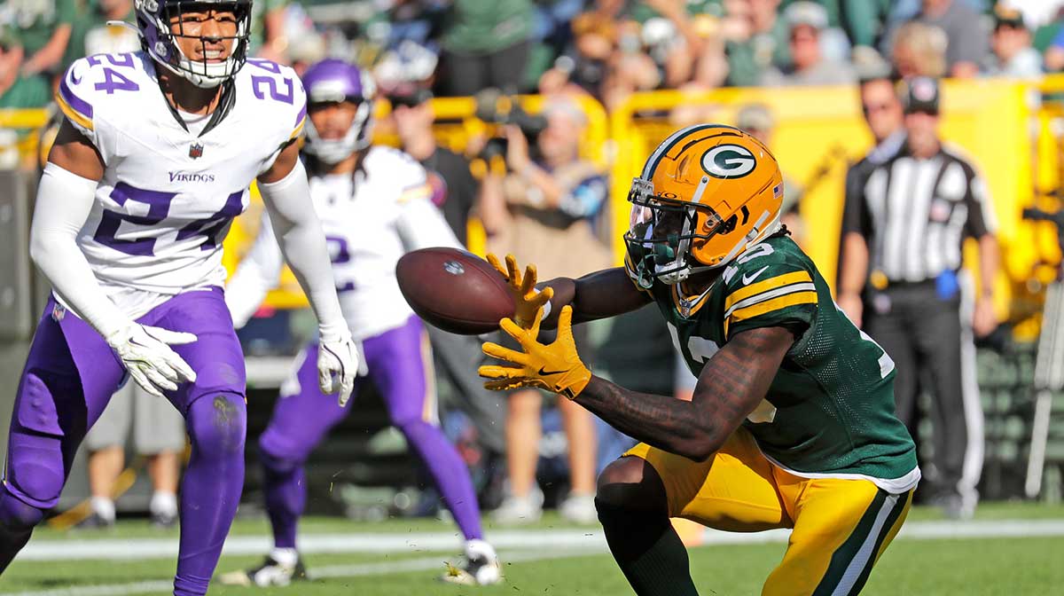 Green Bay Packers wide receiver Dontayvion Wicks (13) scores a touchdown in the fourth quarter against Minnesota Vikings safety Camryn Bynum (24) during their football game Sunday, September 29, 2024, at Lambeau Field in Green Bay, Wisconsin.