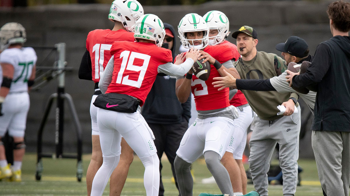 Fellow quarterbacks pressure Oregon quarterback Dante Moore as part of a throwing drill during practice with the Oregon Ducks Saturday, April 6, 2024 at the Hatfield-Dowlin Complex in Eugene, Ore.