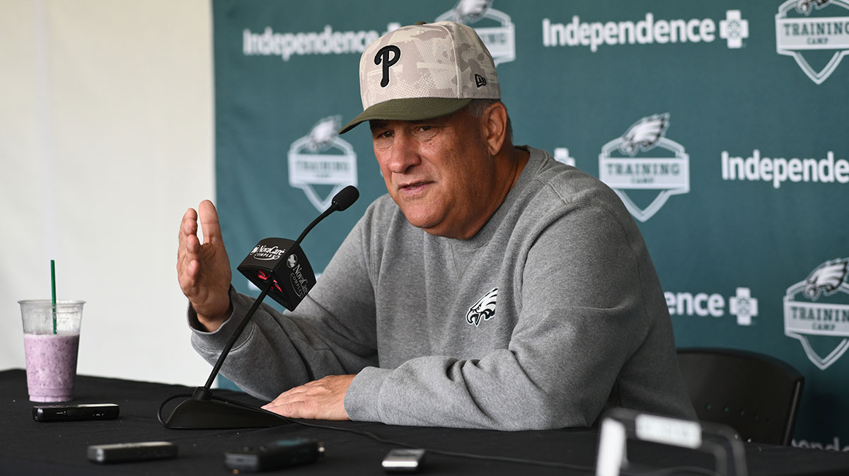 Eagles defensive coordinator Vic Fangio addresses media during training camp at NovaCare Complex with Eagles' DeJean Cooper in the background
