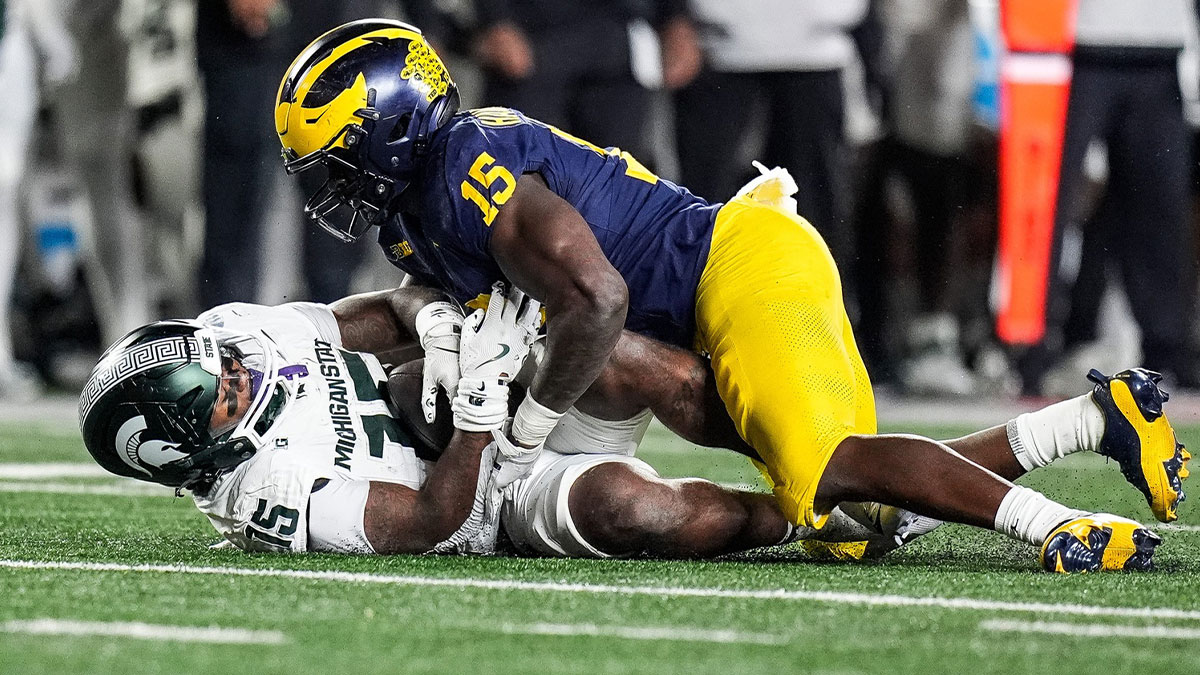 Michigan linebacker Ernest Hausmann (15) tackles Michigan State running back Kay'Ron Lynch-Adams (15) during the first half at Michigan Stadium
