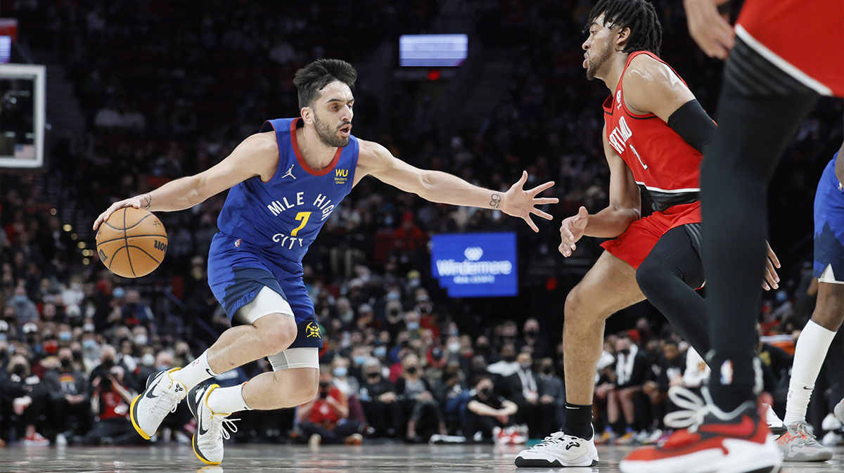 Denver Nuggets point guard Facundo Campazzo (7) dribbles the ball while defended by Portland Trail Blazers power forward Trendon Watford (2) during the first half at Moda Center.