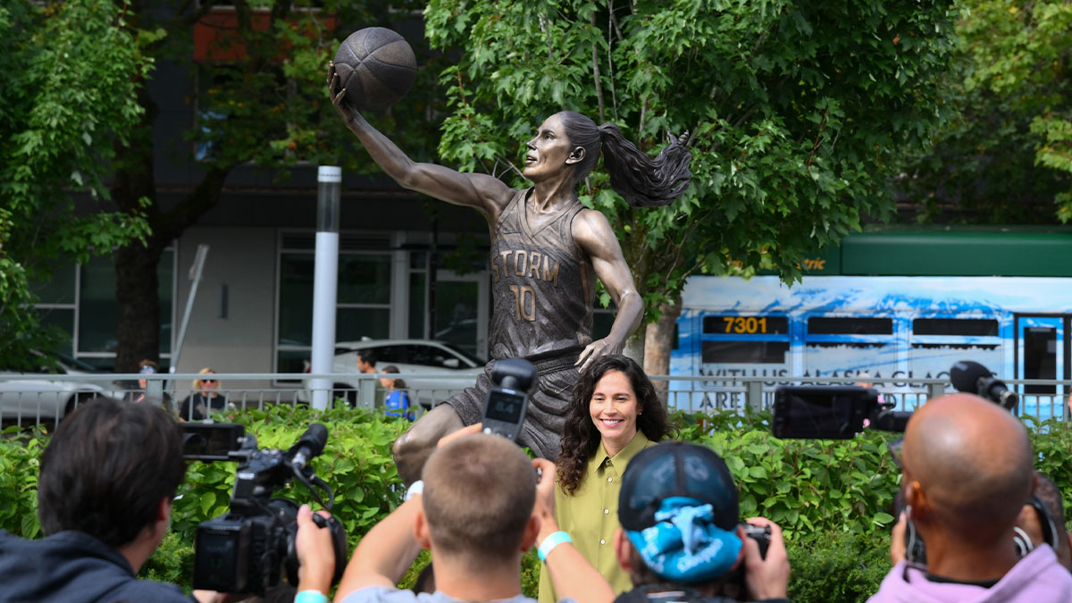 Former Seattle Storm player, Sue Bird, poses for a photo in front of her statue prior to the game between the Seattle Storm and the Phoenix Mercury at Climate Pledge Arena.