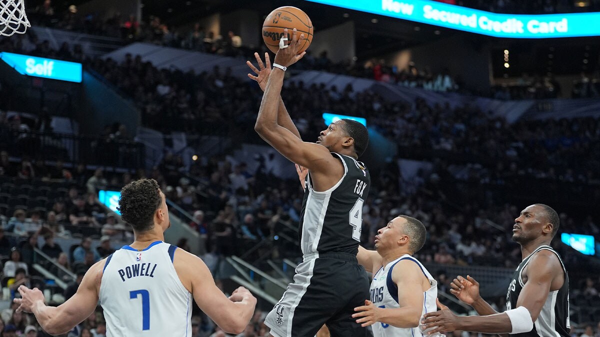 San Antonio Spurs guard De'Aaron Fox (4) shoots over Dallas Mavericks center Dwight Powell (7) in the first half at Frost Bank Center.