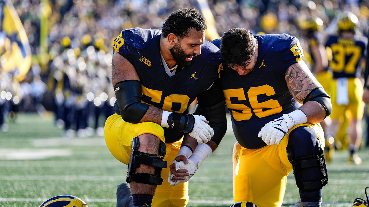 Michigan offensive lineman Giovanni El-Hadi (58), left, and offensive lineman Dominick Giudice (56) pray together before kickoff against Oregon at Michigan Stadium