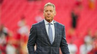 hall of fame Troy Aikman prior to a game between the New Orleans Saints and the Kansas City Chiefs at GEHA Field at Arrowhead Stadium with Commanders head coach Dan Quinn & Commanders quarterback Jayden Daniels in the background