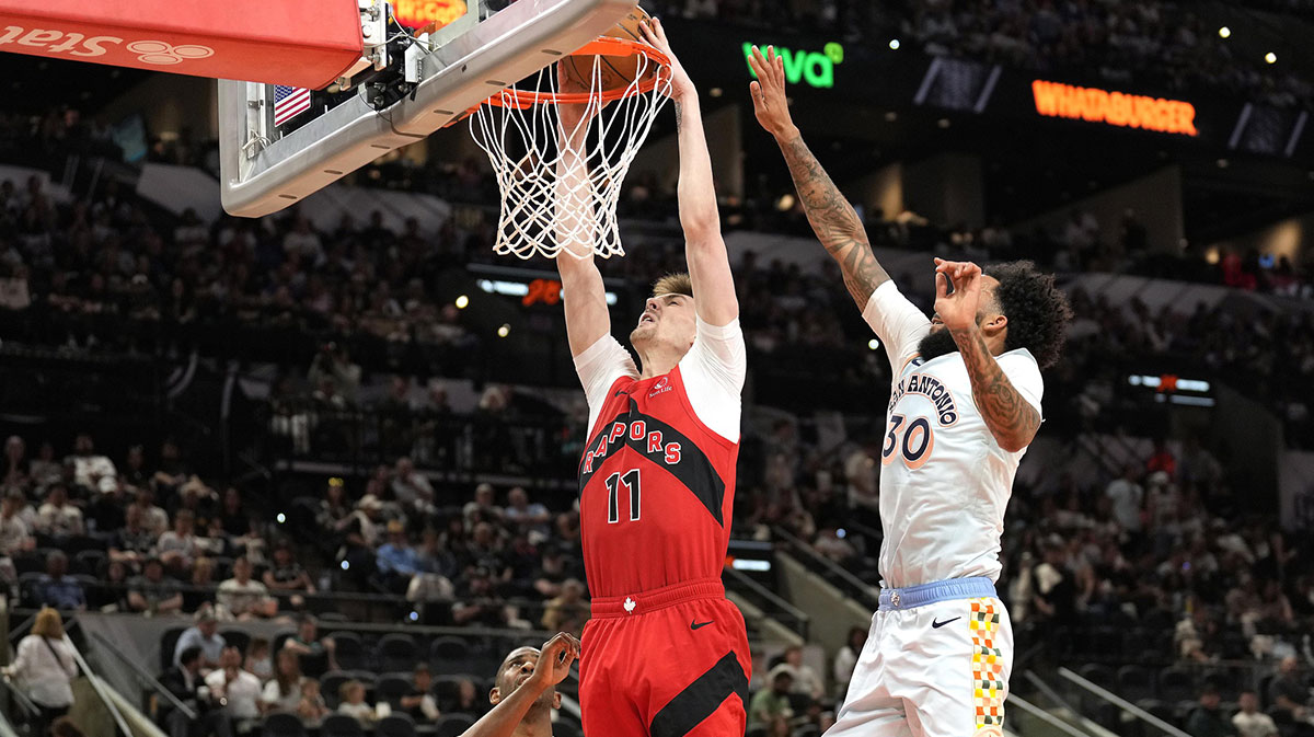 Toronto Raptors center Colin Castleton (11) dunks while defended by San Antonio Spurs forward Julian Champagnie (30) during the first half at Frost Bank Center.