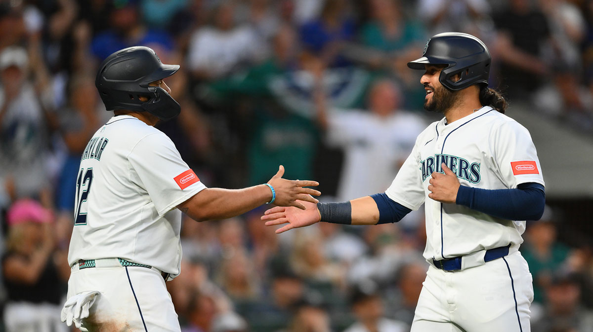 Seattle Mariners first baseman Josh Naylor (12) and third baseman Eugenio Suarez (28) celebrate after both scored a run against the Chicago White Sox during the sixth inning at T-Mobile Park.