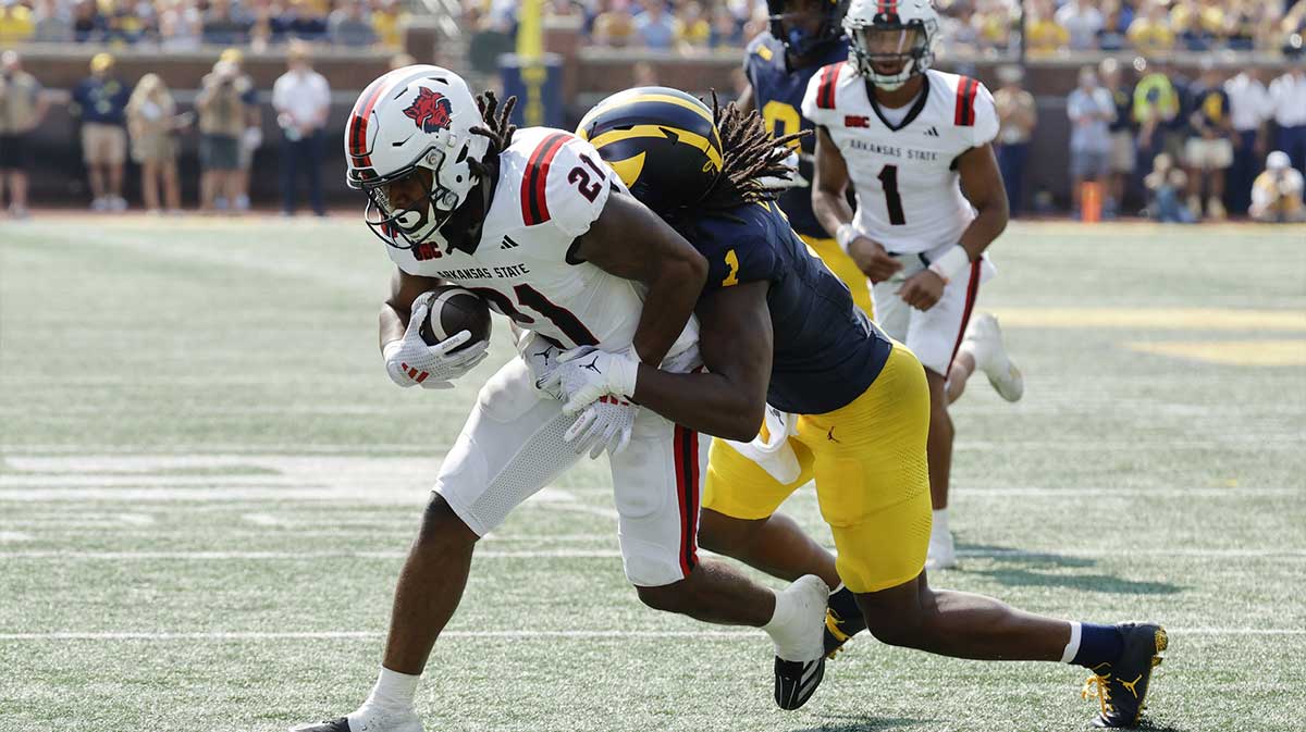 Arkansas State Red Wolves running back Zak Wallace (21) is tackled by Michigan Wolverines linebacker Jaishawn Barham (1) during the first half at Michigan Stadium.