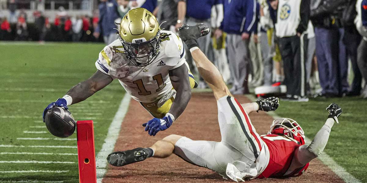 Georgia Tech Yellow Jackets running back Jamal Haynes (11) scores a touchdown past Georgia Bulldogs defensive back Dan Jackson (17) during the first half at Sanford Stadium.