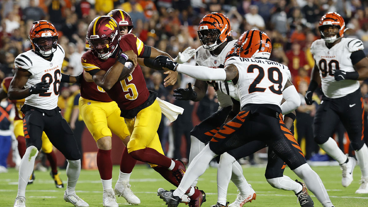 Aug 18, 2025; Landover, Maryland, USA; Washington Commanders quarterback Jayden Daniels (5) runs with the ball past Cincinnati Bengals defensive tackle Howard Cross III (95) and Bengals cornerback Cam Taylor-Britt (29) to score a touchdown during the first quarter at Northwest Stadium.