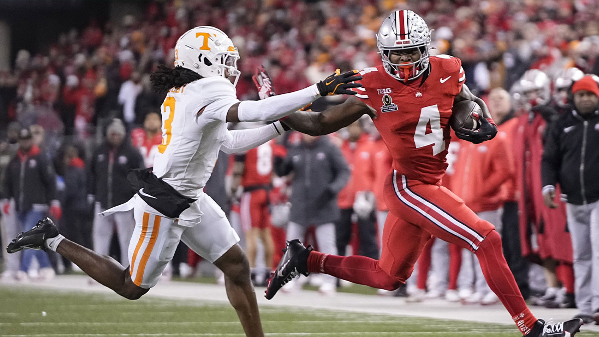 Ohio State Buckeyes wide receiver Jeremiah Smith (4) runs past Tennessee Volunteers defensive back Jermod McCoy (3) during the first half of the College Football Playoff first round game at Ohio Stadium in Columbus on Dec. 21, 2024.