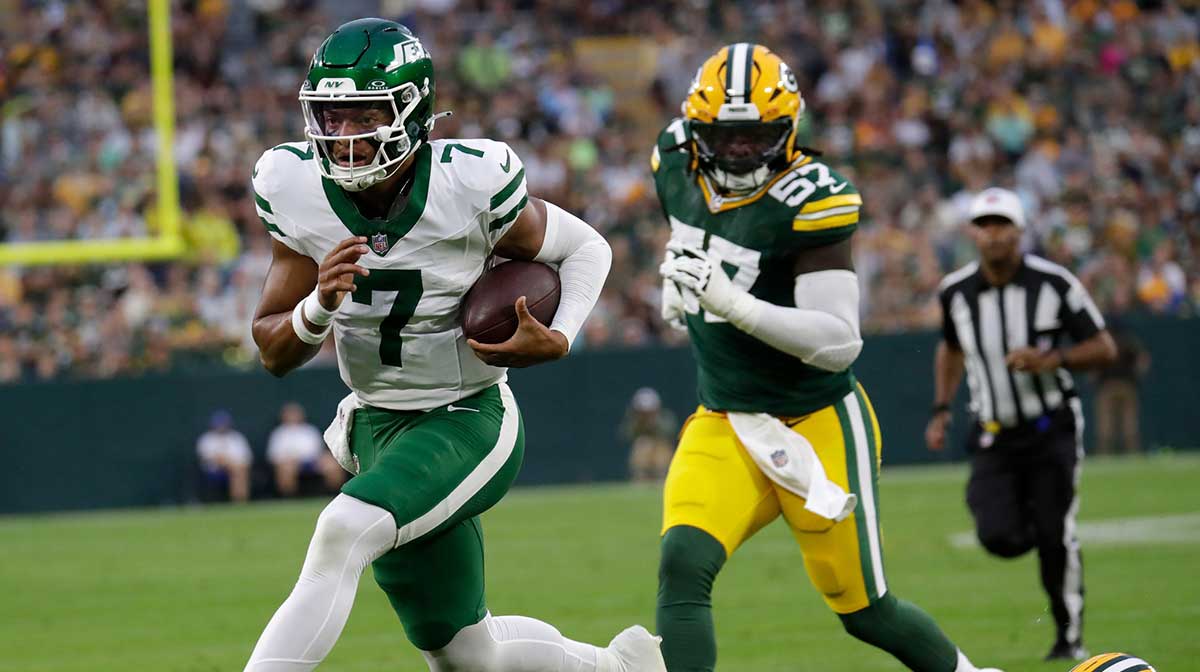 New York Jets quarterback Justin Fields (7) breaks away for a touchdown run against Green Bay Packers cornerback Keisean Nixon (25) during their football game.