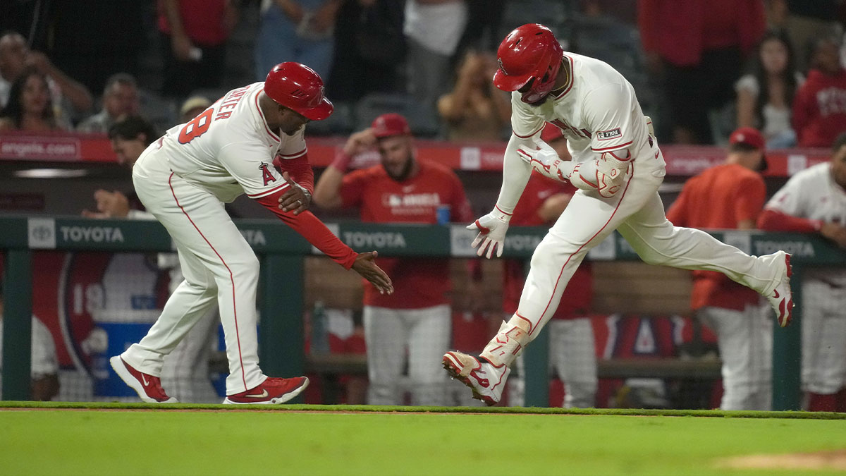 Los Angeles Angels right fielder Jo Adell (7) is congratulated by third base coach Bo Porter (88) after hitting a home run in the eighth inning against the Cincinnati Reds at Angel Stadium.