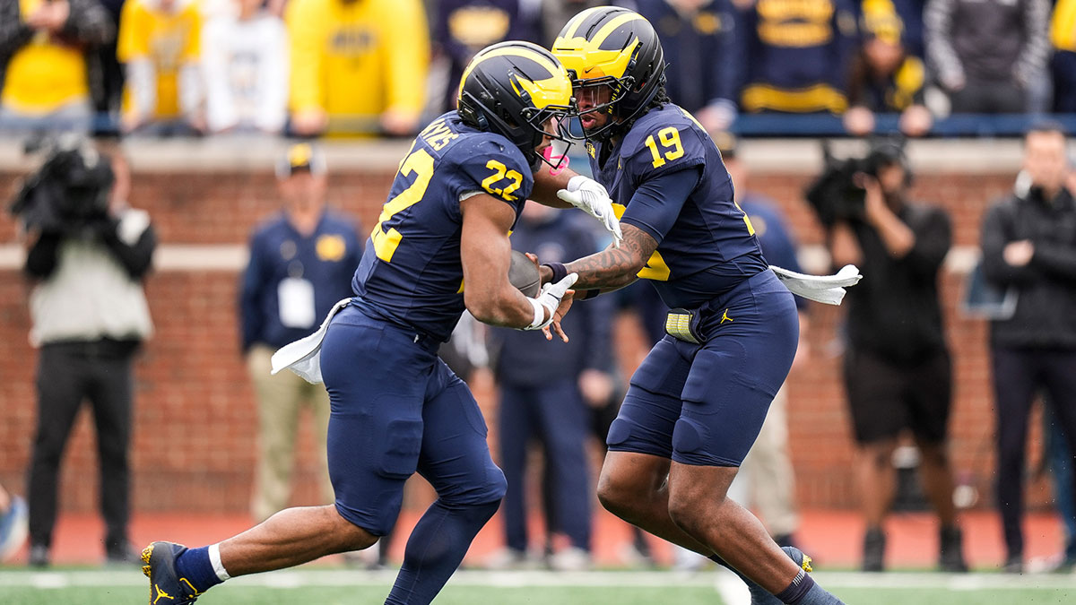 Team Blue quarterback Bryce Underwood (19) hands the ball to running back Justice Haynes (22) during the first half of the spring game at Michigan Stadium