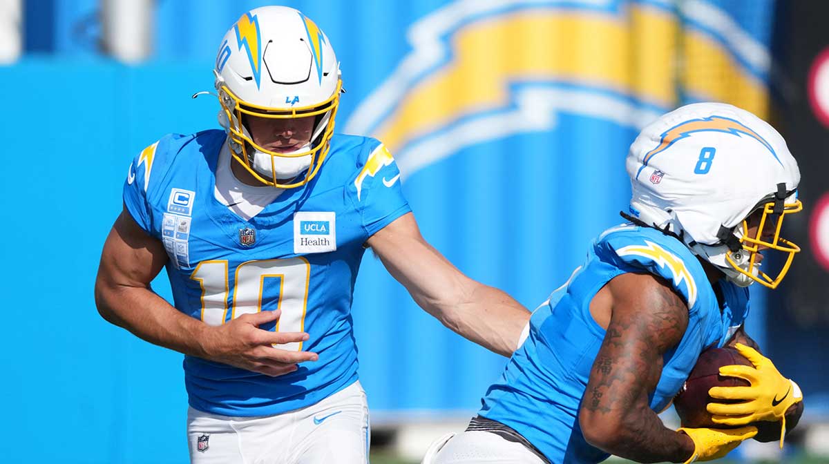 Los Angeles Chargers quarterback Justin Herbert (10) hands the ball off to running back Omarion Hampton (8) during training camp at The Bolt.