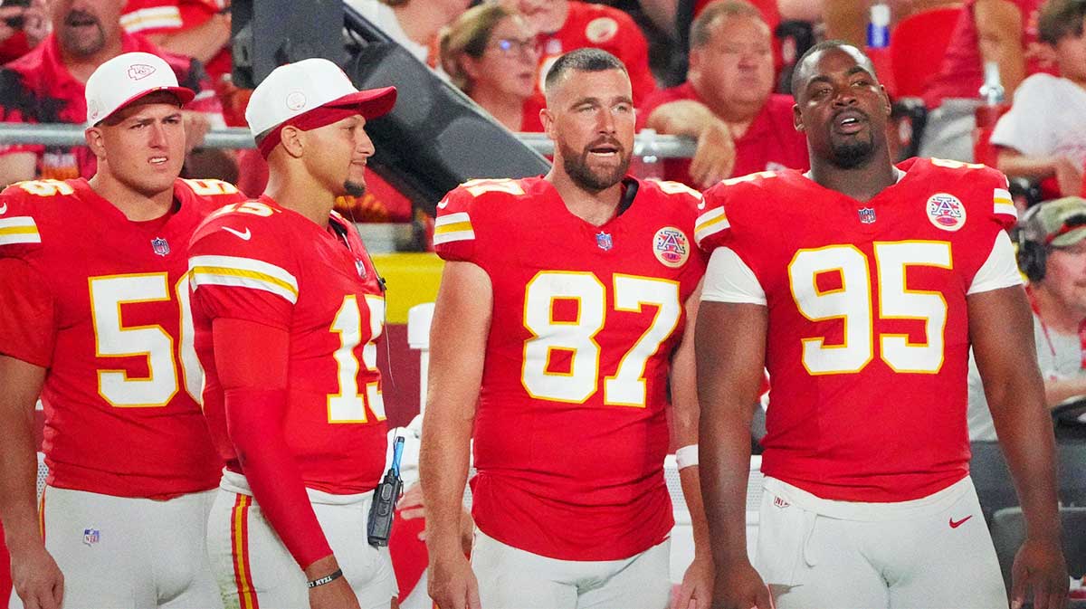 Kansas City Chiefs defensive end George Karlaftis (56) and quarterback Patrick Mahomes (15) and tight end Travis Kelce (87) and defensive tackle Chris Jones (95) watch play against the Chicago Bears during the second half of the game at GEHA Field at Arrowhead Stadium.