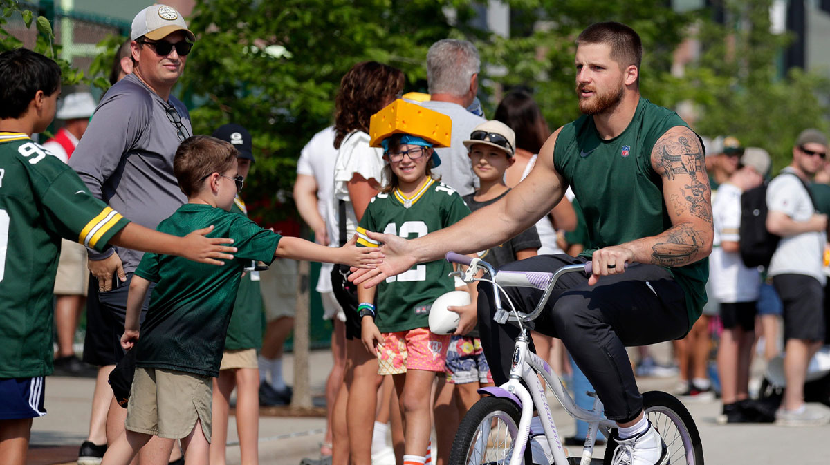 Green Bay Packers tight end Tucker Kraft (85) greets fans while participating in the Dream Drive bicycle ride before practice on Aug. 1, 2025, in Ashwaubenon, Wis.