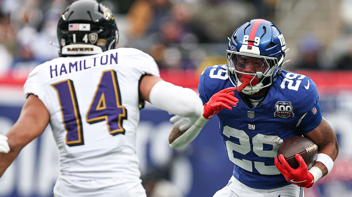 New York Giants running back Tyrone Tracy Jr. (29) carries the ball asBaltimore Ravens safety Kyle Hamilton (14) pursues during the first half at MetLife Stadium.