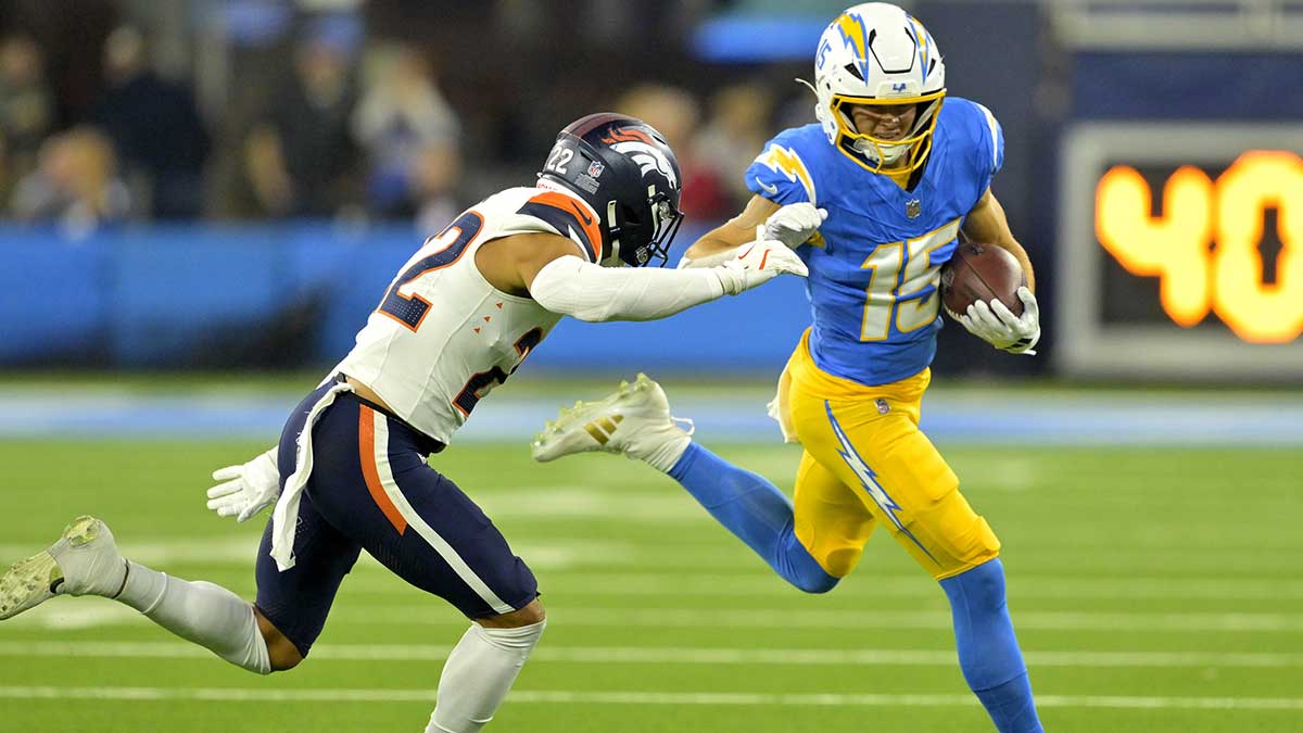Los Angeles Chargers wide receiver Ladd McConkey (15) avoids a tackle by Denver Broncos safety Brandon Jones (22) as he runs for a first down after a complete pass in the first half at SoFi Stadium.