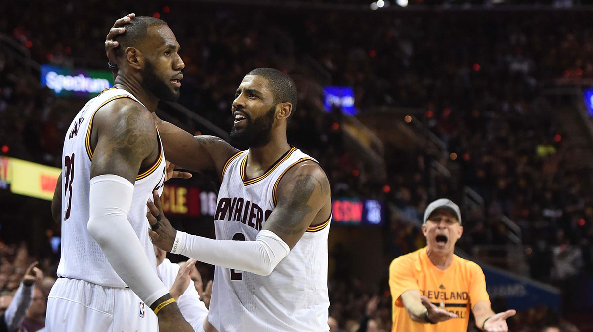Cleveland Cavaliers forward LeBron James (23) is greeted by guard Kyrie Irving (2) as a fan reacts during the third quarter against the Golden State Warriors in game three of the 2017 NBA Finals at Quicken Loans Arena.