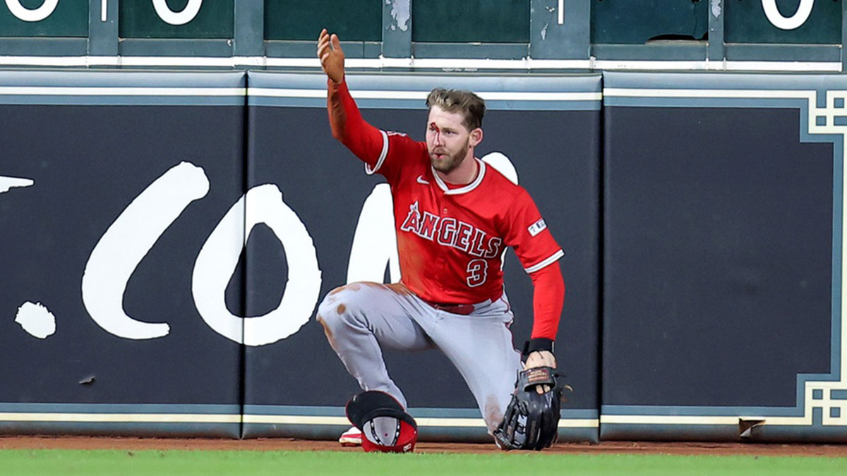 Los Angeles Angels left fielder Taylor Ward (3) calls for the trainer after sustaining an injury while attempting to field a ball hit by Houston Astros second baseman Ramon Urias (29, not shown) during the eighth inning at Daikin Park.