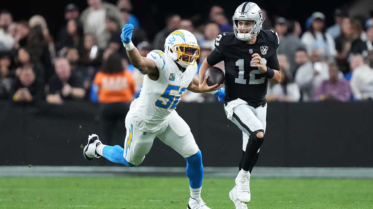 Las Vegas Raiders quarterback Aidan O'Connell (12) carries the ball against Los Angeles Chargers linebacker Khalil Mack (52) in the second half at Allegiant Stadium.
