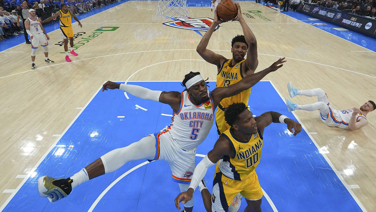 Indiana Pacers center Tony Bradley (13) rebounds over Oklahoma City Thunder guard Luguentz Dort (5) and Indiana Pacers guard Bennedict Mathurin (00) during the first half during game five of the 2025 NBA Finals at Paycom Center.