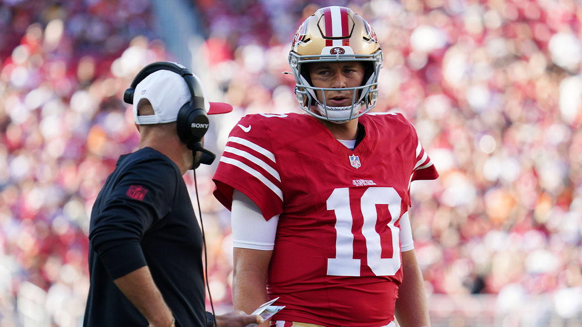 San Francisco 49ers quarterback Mac Jones (10) talks with quarterbacks coach Mick Lombardi in the first quarter against the Denver Broncos