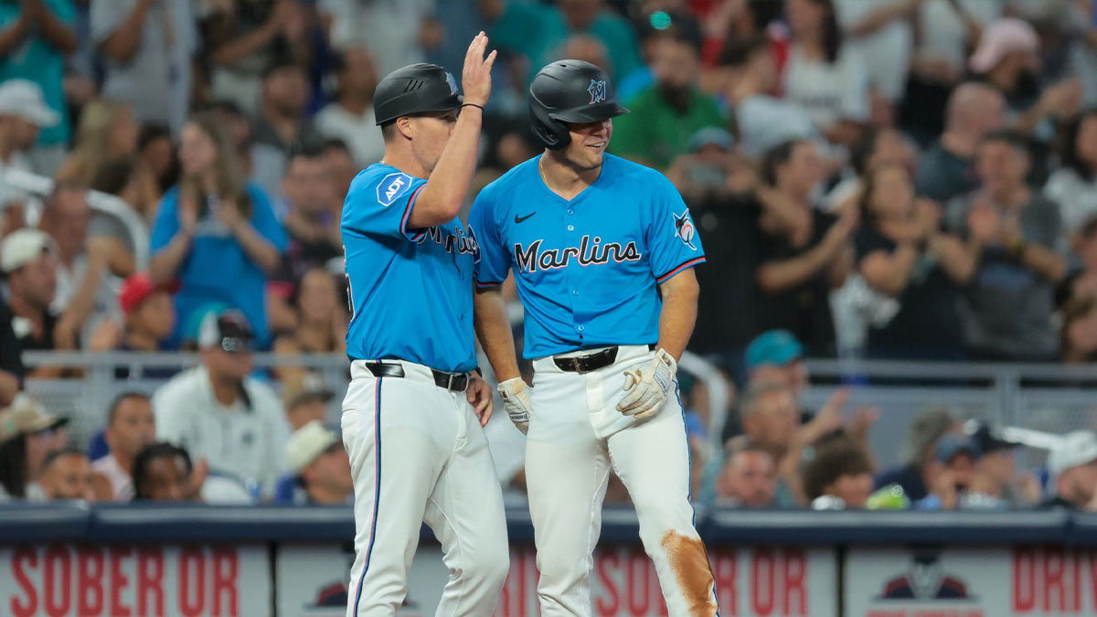 Miami Marlins center fielder Jakob Marsee (87) celebrates with third base coach Blake Lalli (45) after hitting an RBI triple against the New York Yankees during the seventh inning at loanDepot Park.