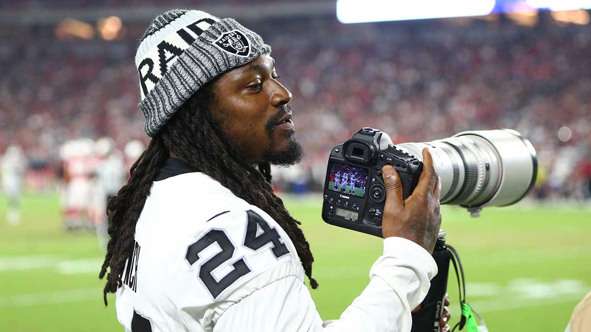 Oakland Raiders running back Marshawn Lynch takes pictures with a Canon camera on the sidelines against the Arizona Cardinals at University of Phoenix Stadium.