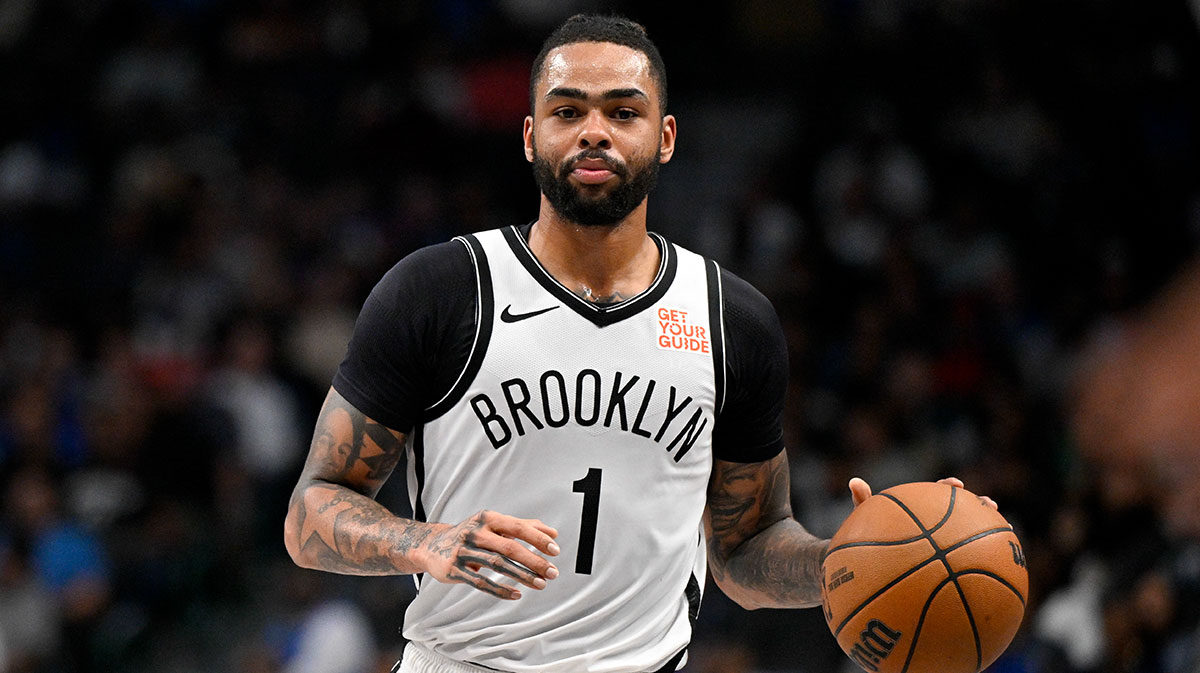 Nets guard D'Angelo Russell (1) in action during the game between the Dallas Mavericks and the Brooklyn Nets at the American Airlines Center with the Nets and Lakers logos in the background
