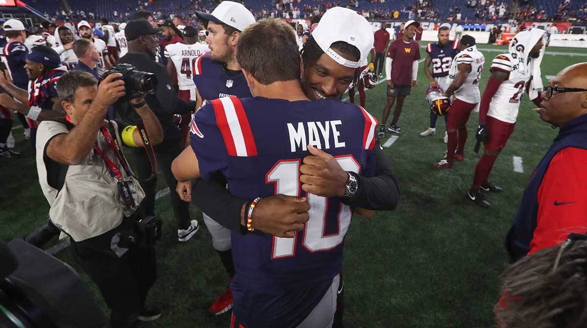 Washington Commanders quarterback Jayden Daniels (5) and New England Patriots quarterback Drake Maye (10) hug after a game at Gillette Stadium.
